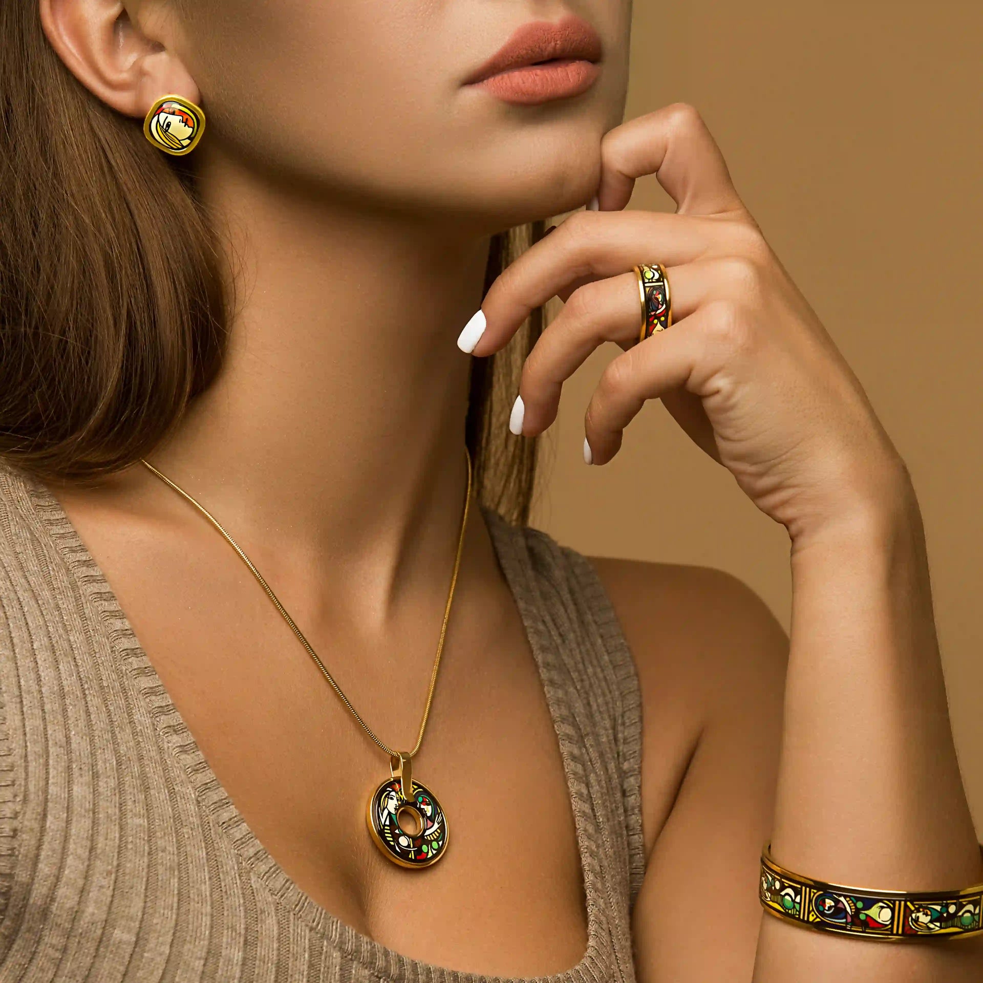 A girl wearing yellow gold earrings, a ring, a bracelet and a necklace from the Picasso's secret collection