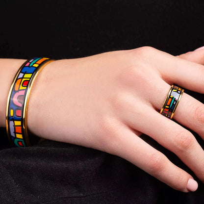Yellow gold bracelet and yellow gold ring with the painting of Friedensreich Hundertwasser's "Spanish Nights" in a center. Jewelry is on a woman's hands