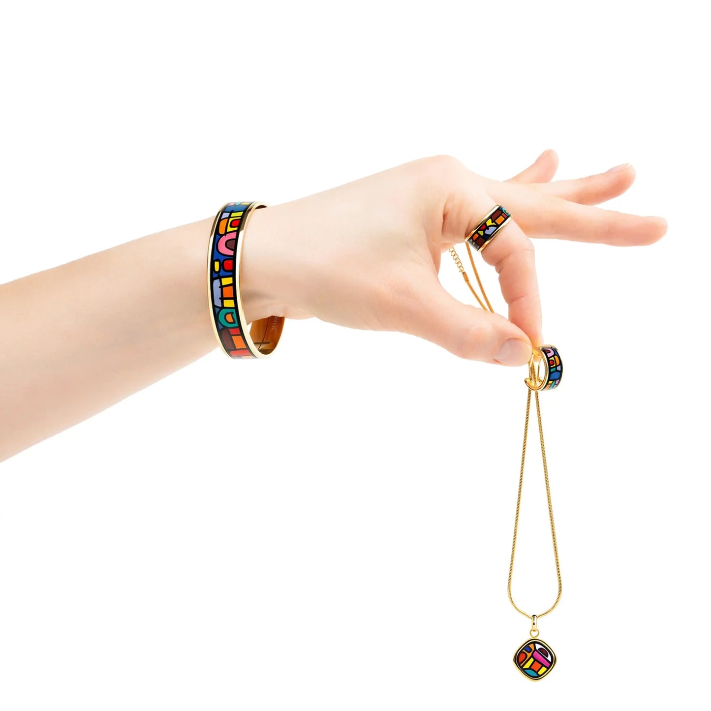Hand with a bracelet and a ring are holding earrings and a necklace from the Spanish Nights collection
