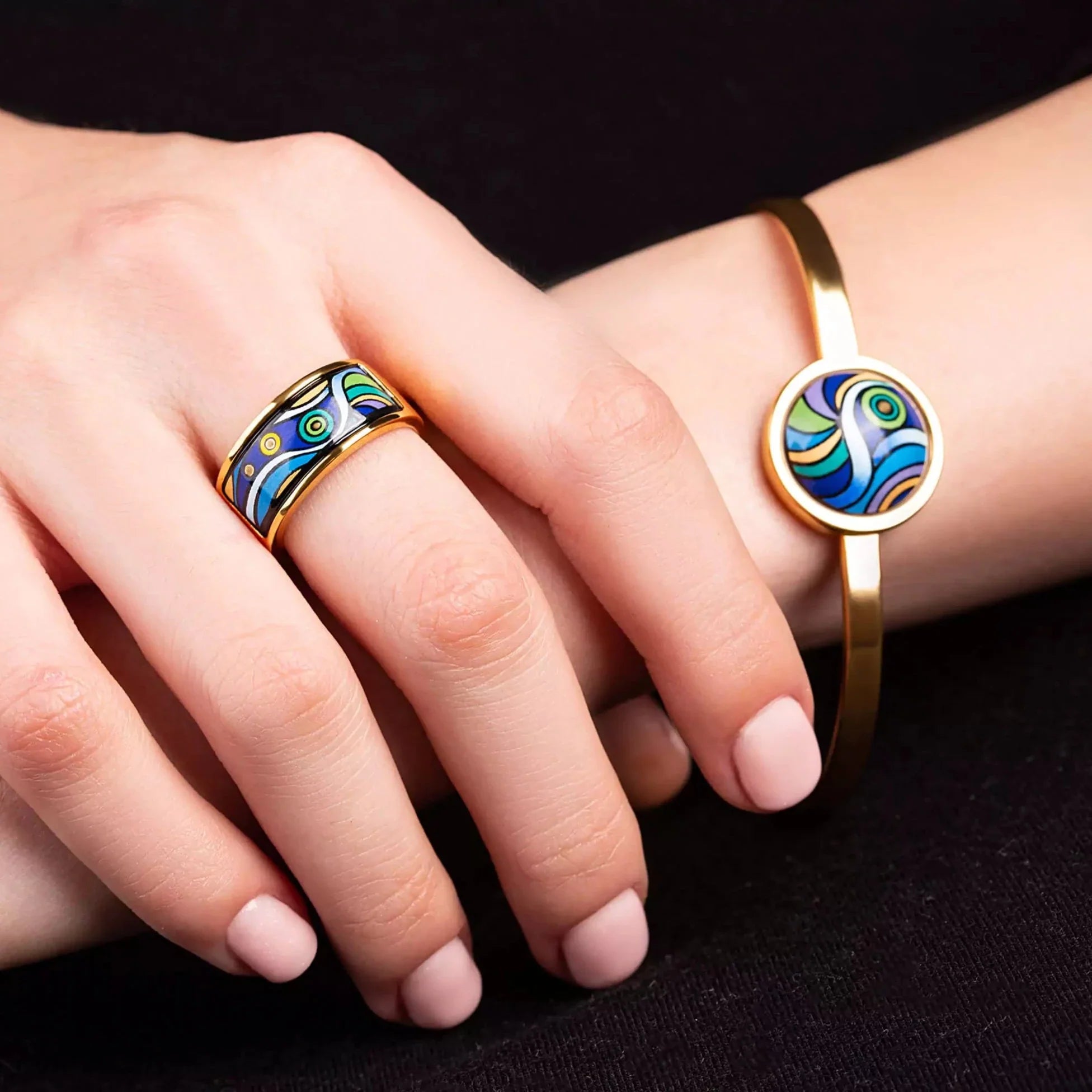 Yellow gold bracelet and yellow gold ring with a round painting of Van Gogh's "Starry Night" in a center. Jewelry is on a woman's hands